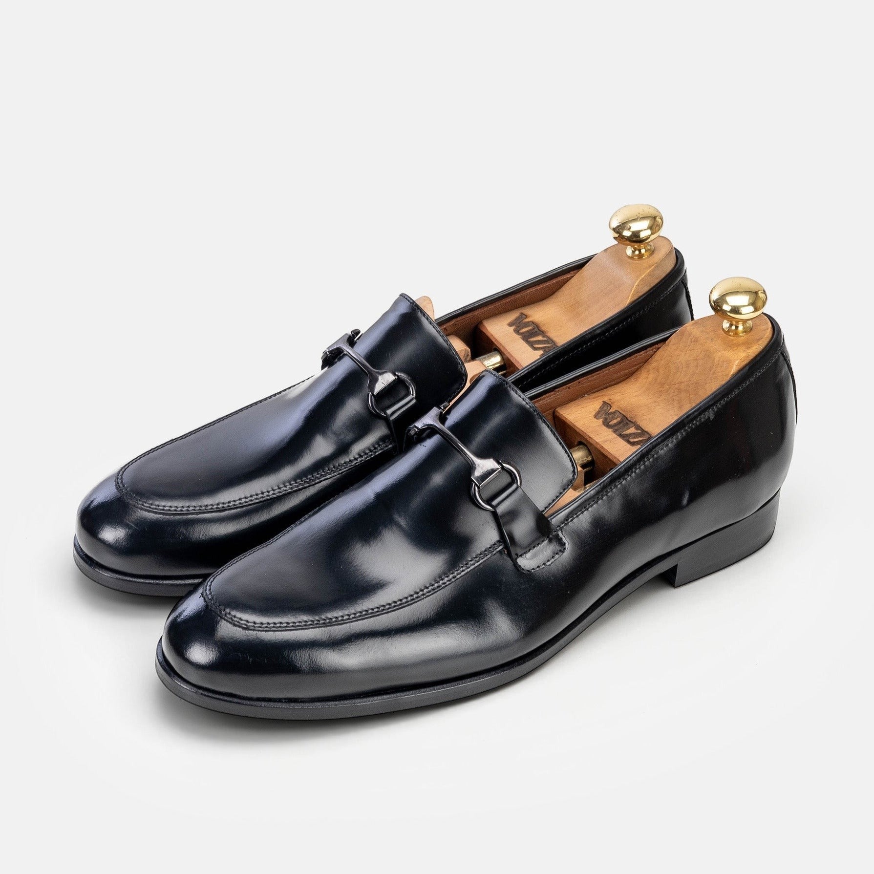 VOLZAK black leather loafers with a polished finish and metal bit detail, featuring wooden shoe trees inside.