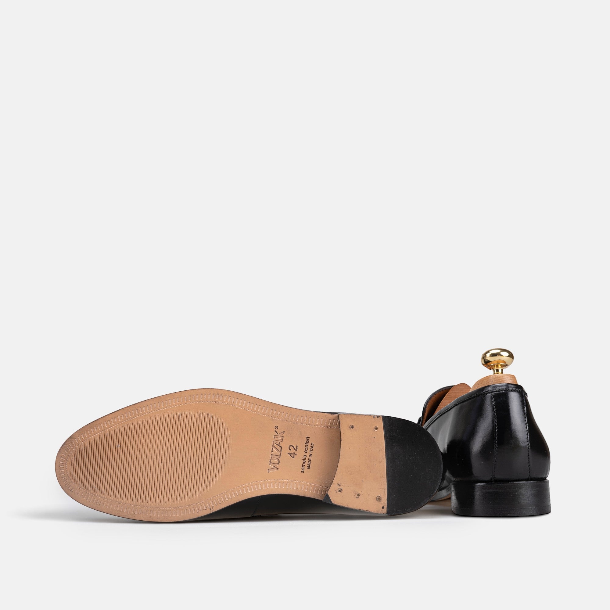 VOLZAK black leather dress shoe showing the tan leather sole with brand logo and heel detail