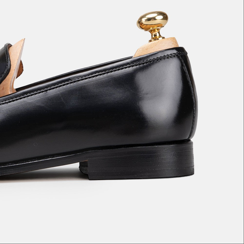 VOLZAK black leather loafer with a polished finish and wooden shoe tree insert, side profile view.