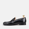 VOLZAK black leather loafer with a sleek silhouette and metal buckle detail, side view