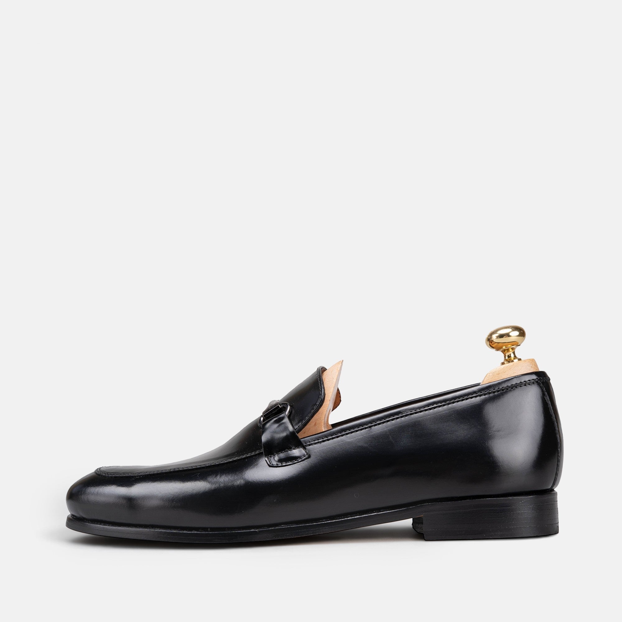 VOLZAK black leather loafer with a sleek silhouette and metal buckle detail, side view