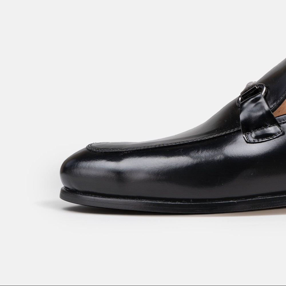 VOLZAK black leather loafer with a polished finish and metal buckle detail, side profile view.