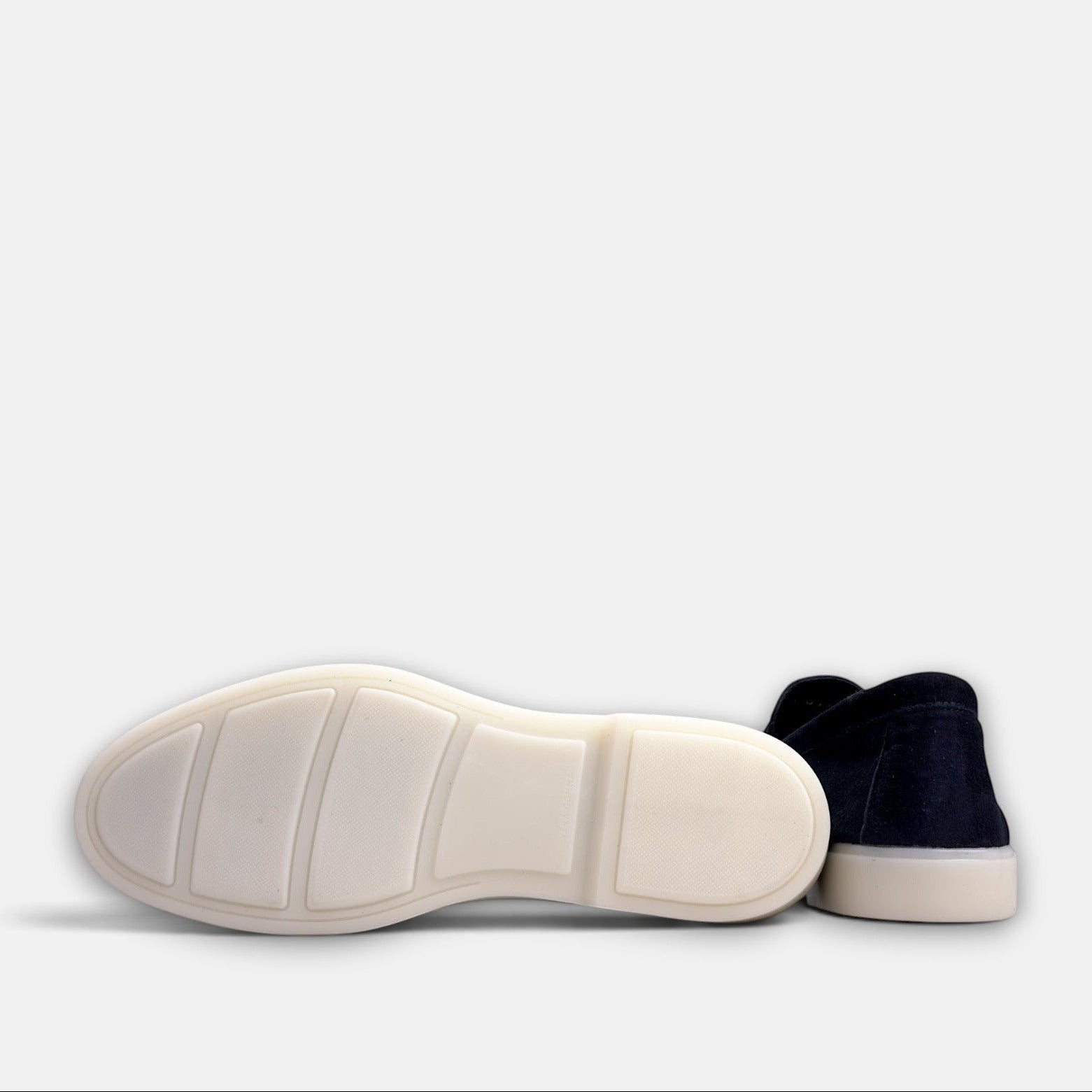 VOLZAK blue suede moccasin shoe showing the white rubber sole tread pattern from a bottom view
