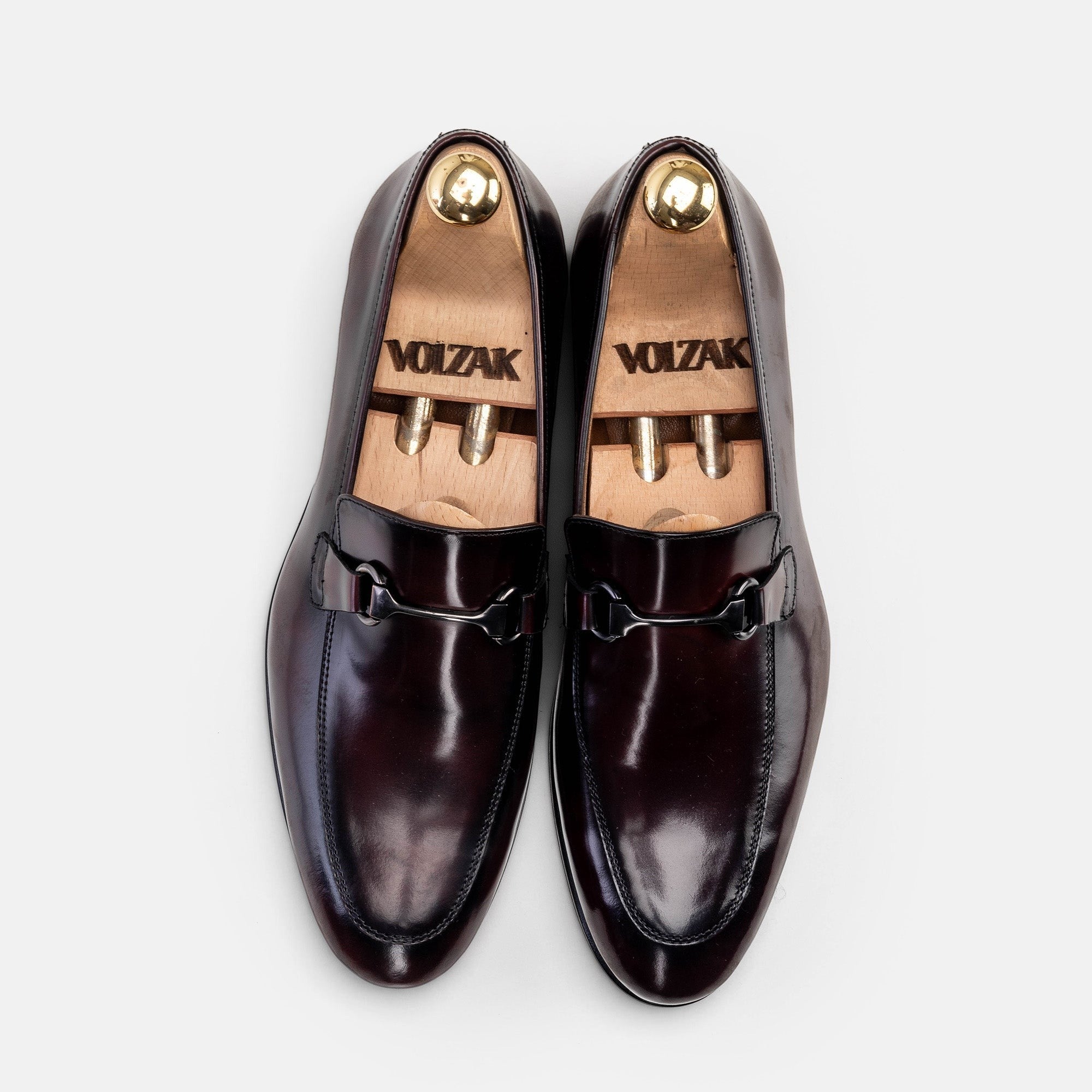 VOLZAK bordeaux leather loafers with metal bit detail and wooden shoe trees, top-down view