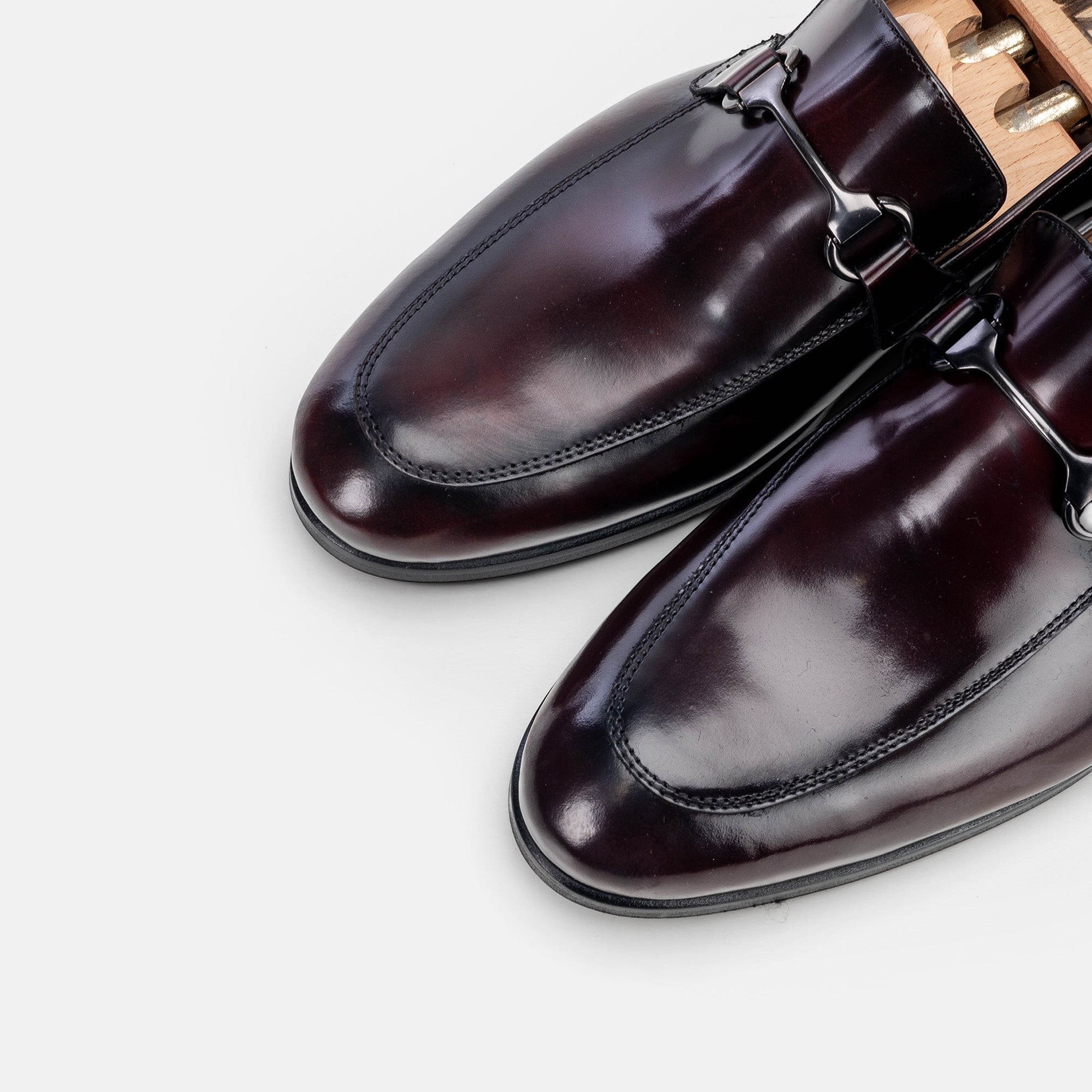 VOLZAK bordeaux leather loafers with a polished finish and metal bit detail on a white background